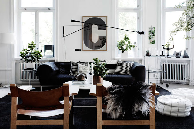 black white living room C poster decor interior design black rug carpet white ottoman pouf
